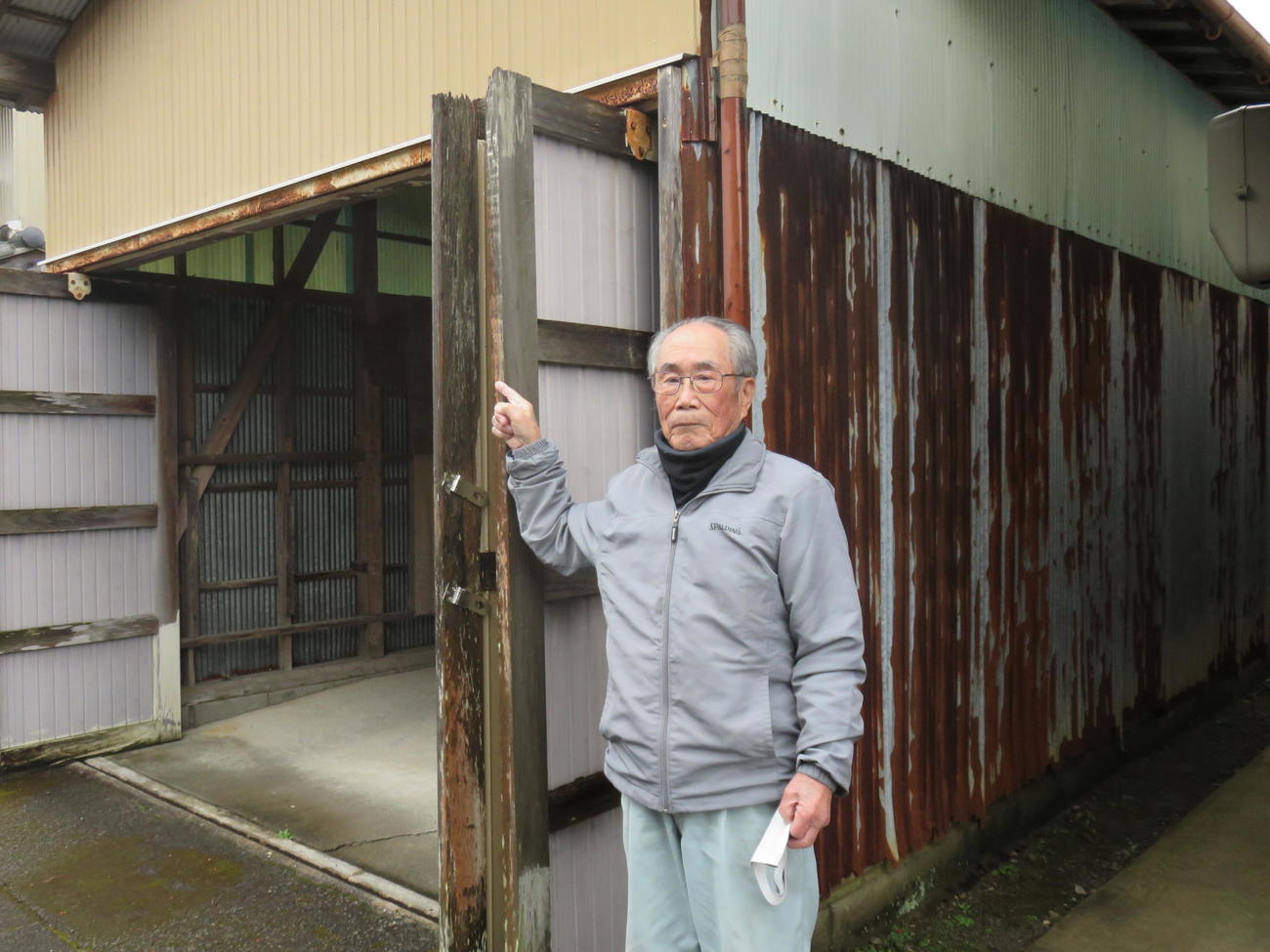 上田氏の生家を指さす幼なじみの吉田徳通氏