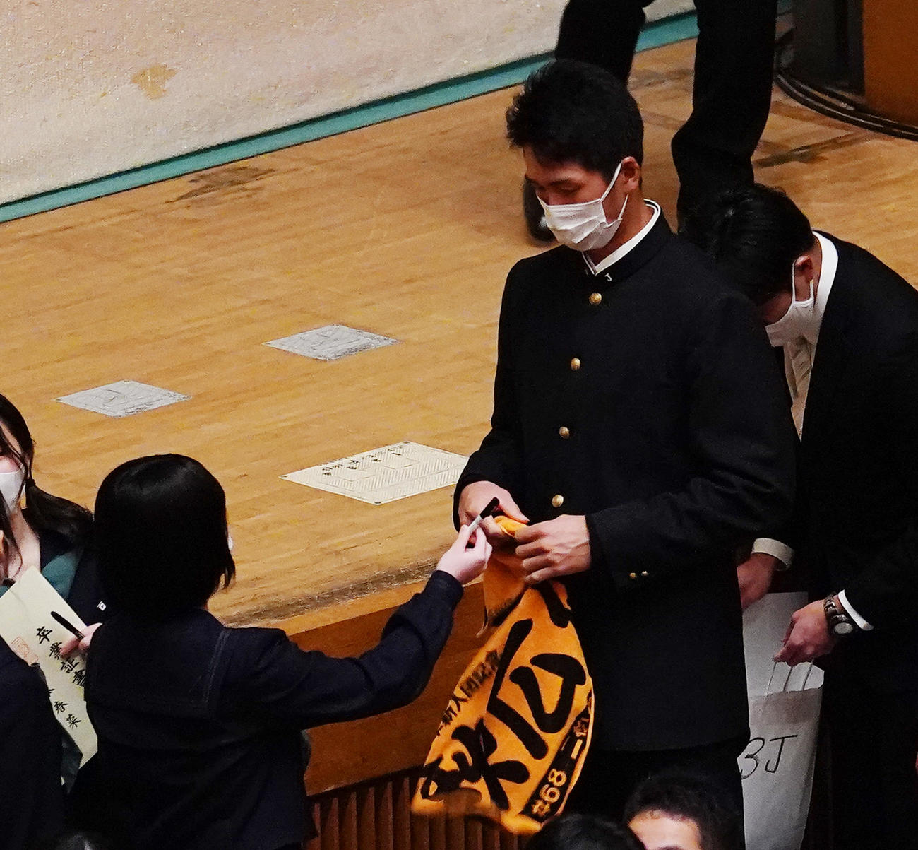二松学舎大付高の卒業式を終え、女子生徒にサインを求められる巨人秋広（右）（撮影・菅敏）