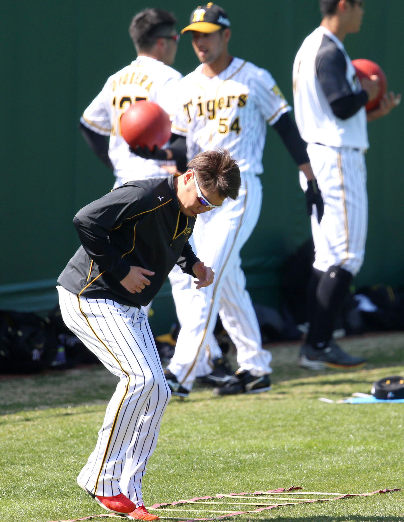 西勇輝（手前）は外野でトレーニングする（撮影・上山淳一）