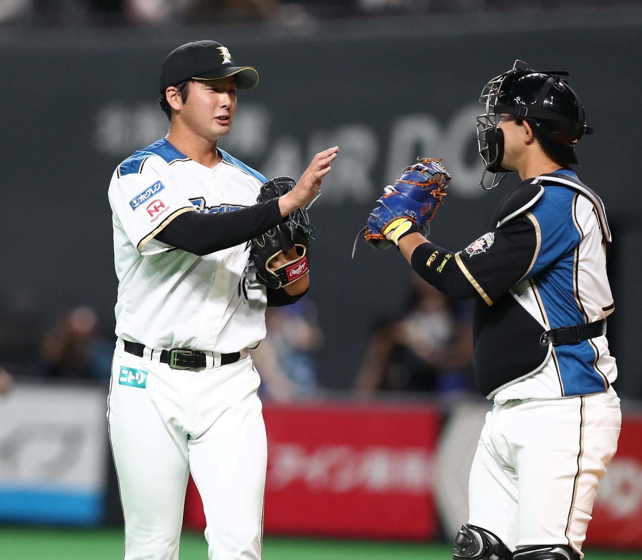 日本ハム対西武　5回表、無失点に抑え宇佐見（右）とタッチする長谷川（撮影・黒川智章）