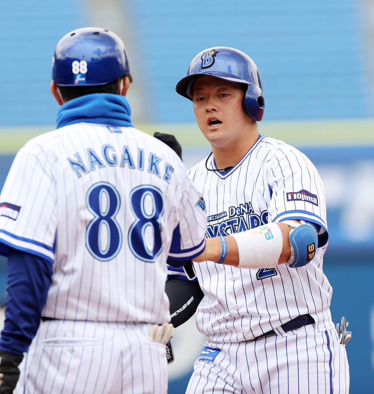 DeNA対オリックス　1回裏DeNA2死、牧（右）は中前安打を放ち永池コーチとタッチ（撮影・鈴木正人）