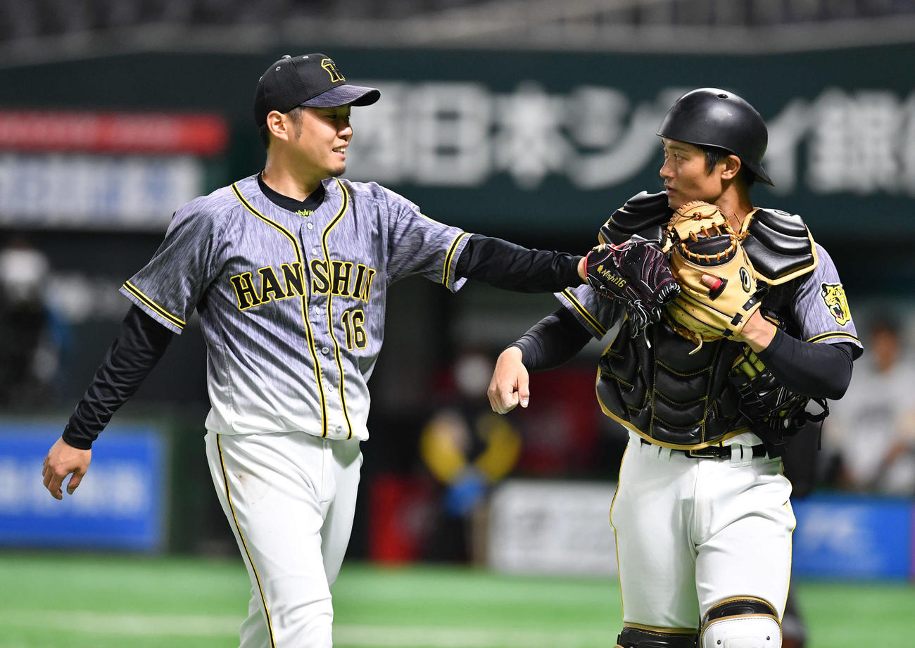 1回裏ソフトバンク2死満塁、ピンチを無失点に抑え、坂本（右）と笑顔でグラブタッチしながらベンチへ戻る西勇輝（撮影・岩下翔太）