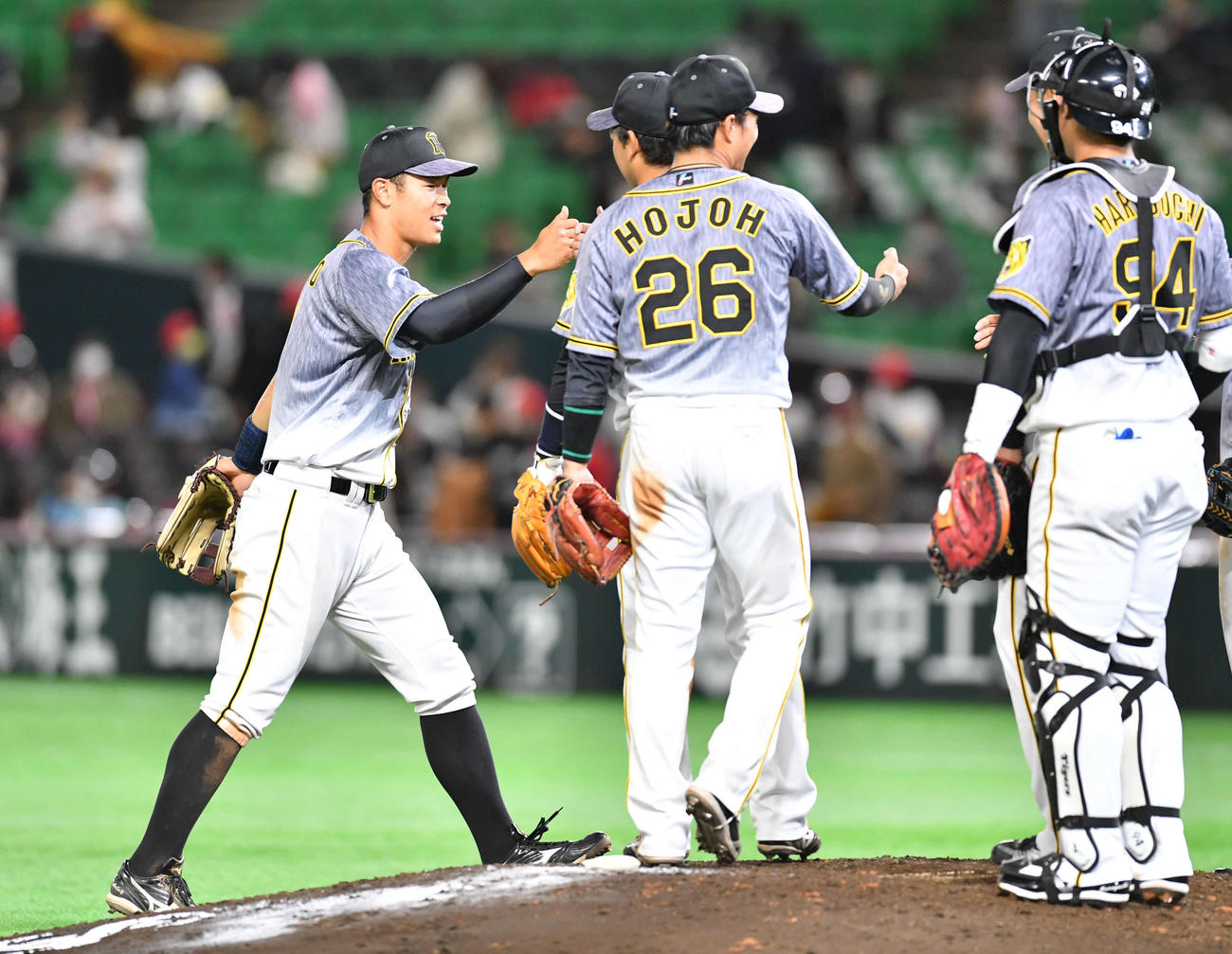 2021年3月5日　ソフトバンク対阪神　ソフトバンクに勝利し、佐藤輝明（左）はナインとグータッチを交わす（撮影・岩下翔太）