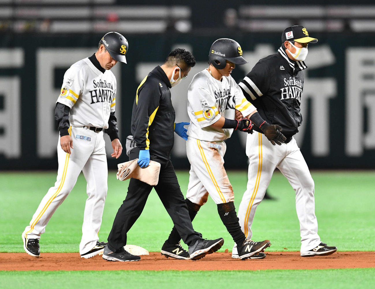 ソフトバンク対阪神　6回裏ソフトバンク1死二塁、藤浪の二塁けん制球が頭に当たり、小久保ヘッドコーチ（右端）らとベンチに戻る牧原大（左から3人目）。左端は村松コーチ（撮影・岩下翔太）
