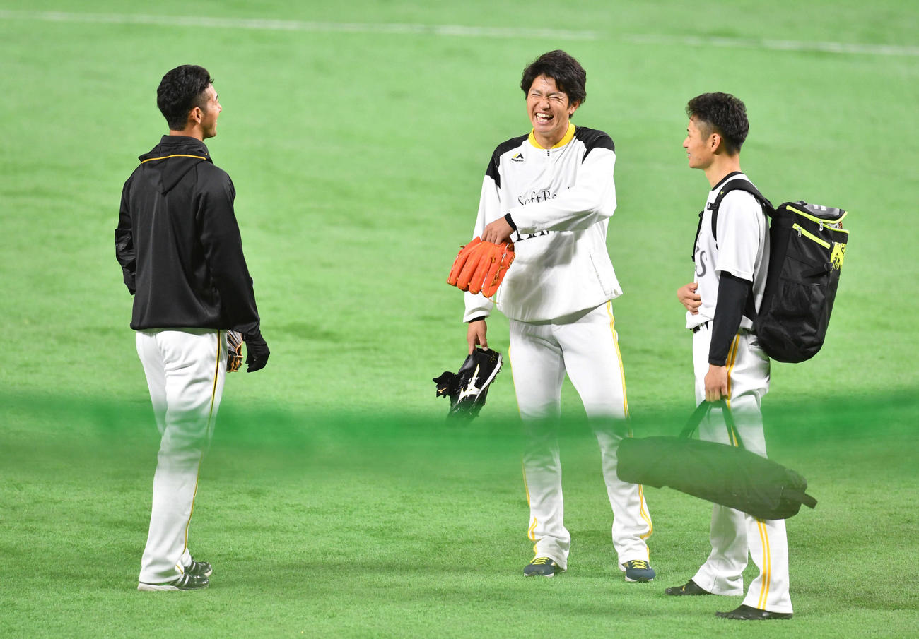 試合前、阪神・加治屋（左）と談笑するソフトバンク高橋礼（中央）と大竹（撮影・岩下翔太）