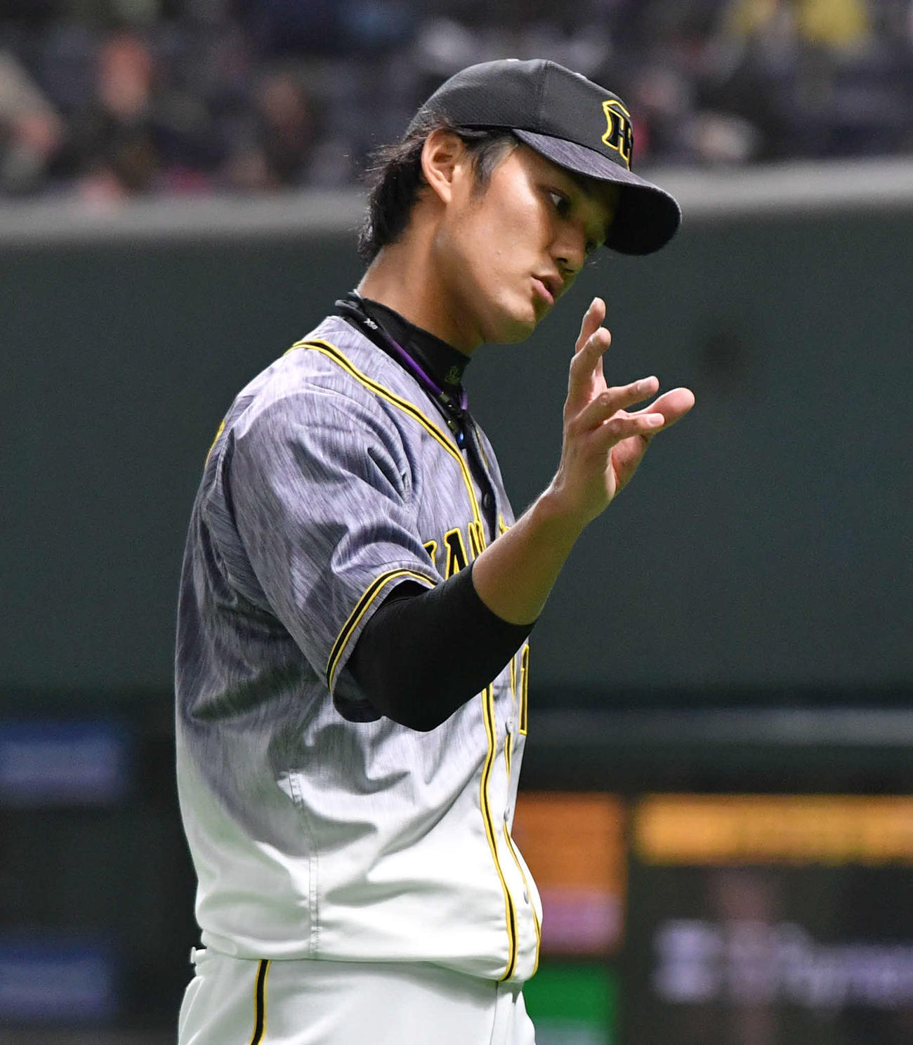 ソフトバンク対阪神　5回裏ソフトバンクの攻撃を3者凡退に抑え、指先の感覚を確かめるようにベンチへ戻る藤浪（撮影・岩下翔太）