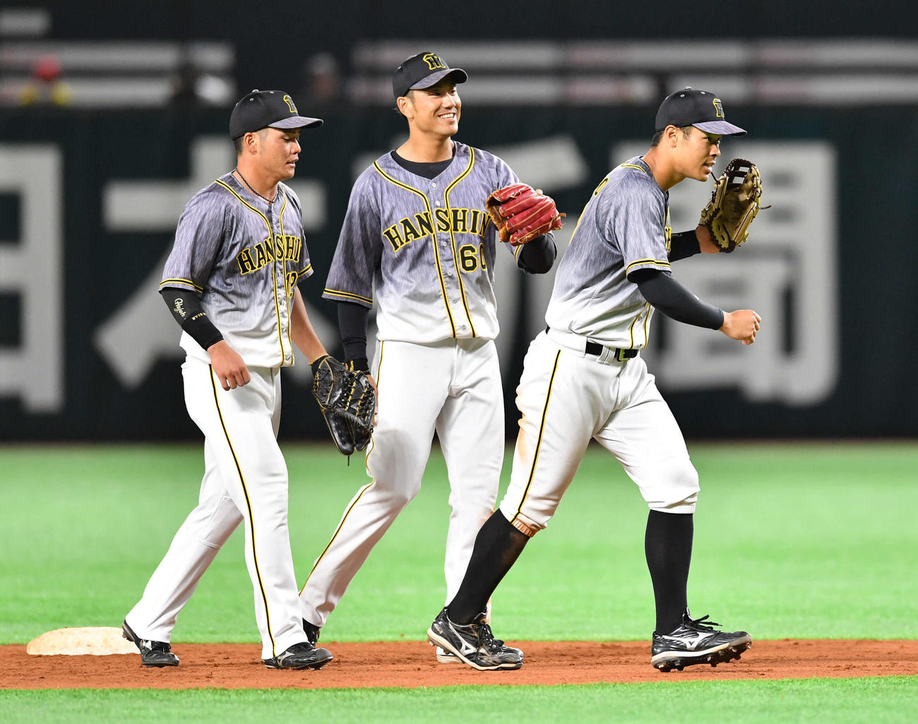 ソフトバンク対阪神　ソフトバンクに勝利し、小野寺（左）、中谷（中央）とグラブタッチを交わしてマウンドへ集まる佐藤輝（撮影・岩下翔太）