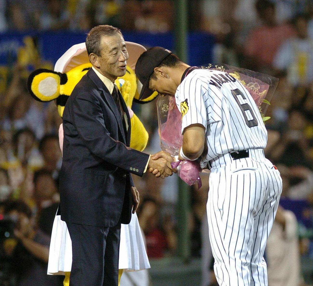 701試合連続フルイニング連続出場を達成した阪神金本（右）に花束を贈る前記録保持者の三宅秀史氏（04年8月1日）