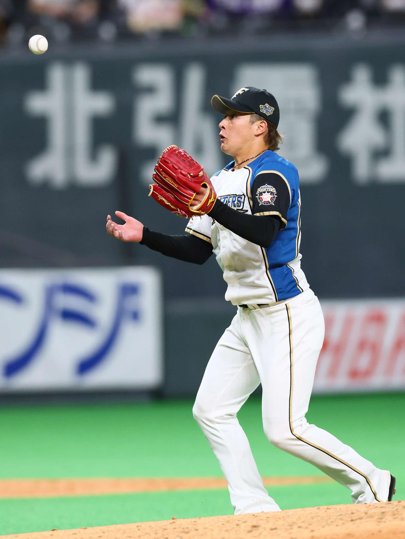 日本ハム対巨人　5回表巨人無死一、三塁、梶谷の打球をグラブではじいた吉田は必死に一塁へ送球するも悪送球となる（撮影・足立雅史）