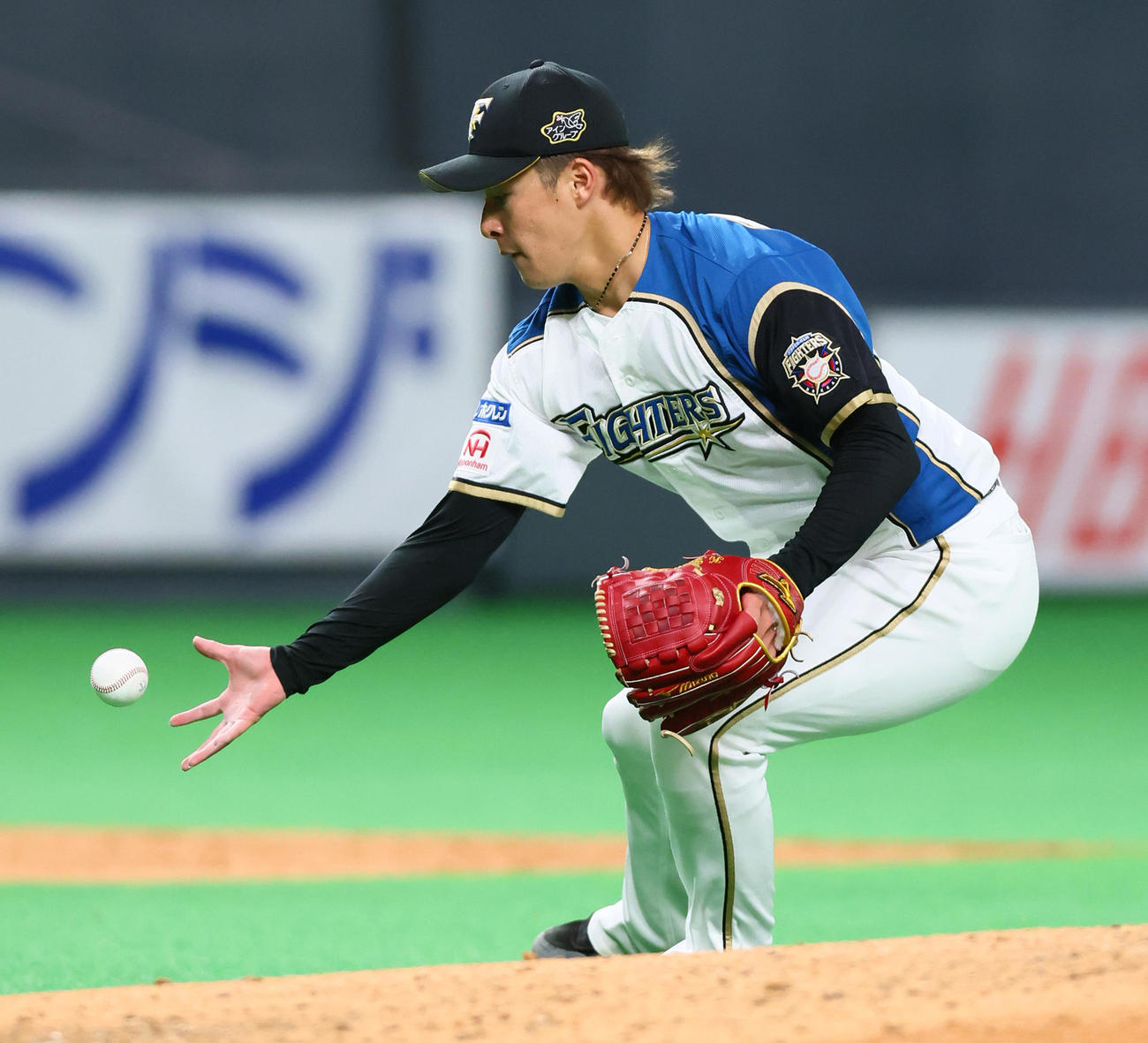 日本ハム対巨人　5回表巨人無死一、三塁、梶谷の打球をグラブではじいた吉田は必死に一塁へ送球するも悪送球となる（撮影・足立雅史）
