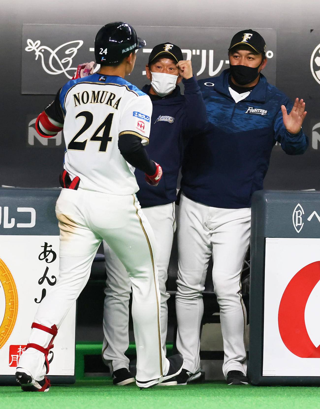 日本ハム対巨人　6回裏日本ハム1死、野村（左）は中越え本塁打を放ち栗山監督（中央）らに迎えられる（撮影・足立雅史）