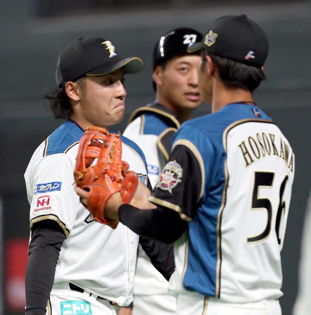 日本ハム対巨人　追加点を許し悔しそうな表情でベンチに戻る日本ハム伊藤（左）（撮影・佐藤翔太）