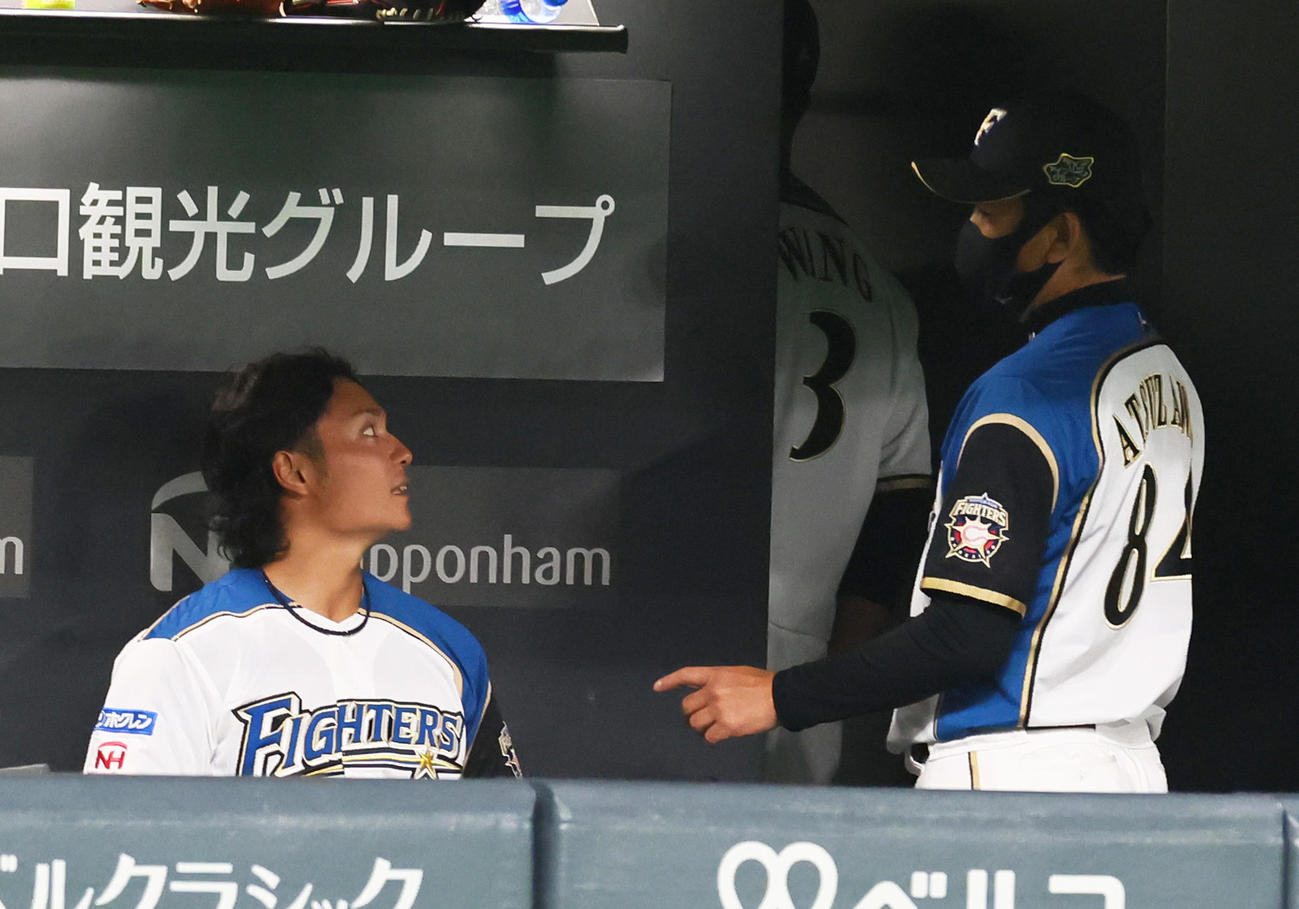 日本ハム対巨人　4回を終えベンチに戻った日本ハム伊藤（左）は厚沢コーチの話に耳を傾ける（撮影・足立雅史）
