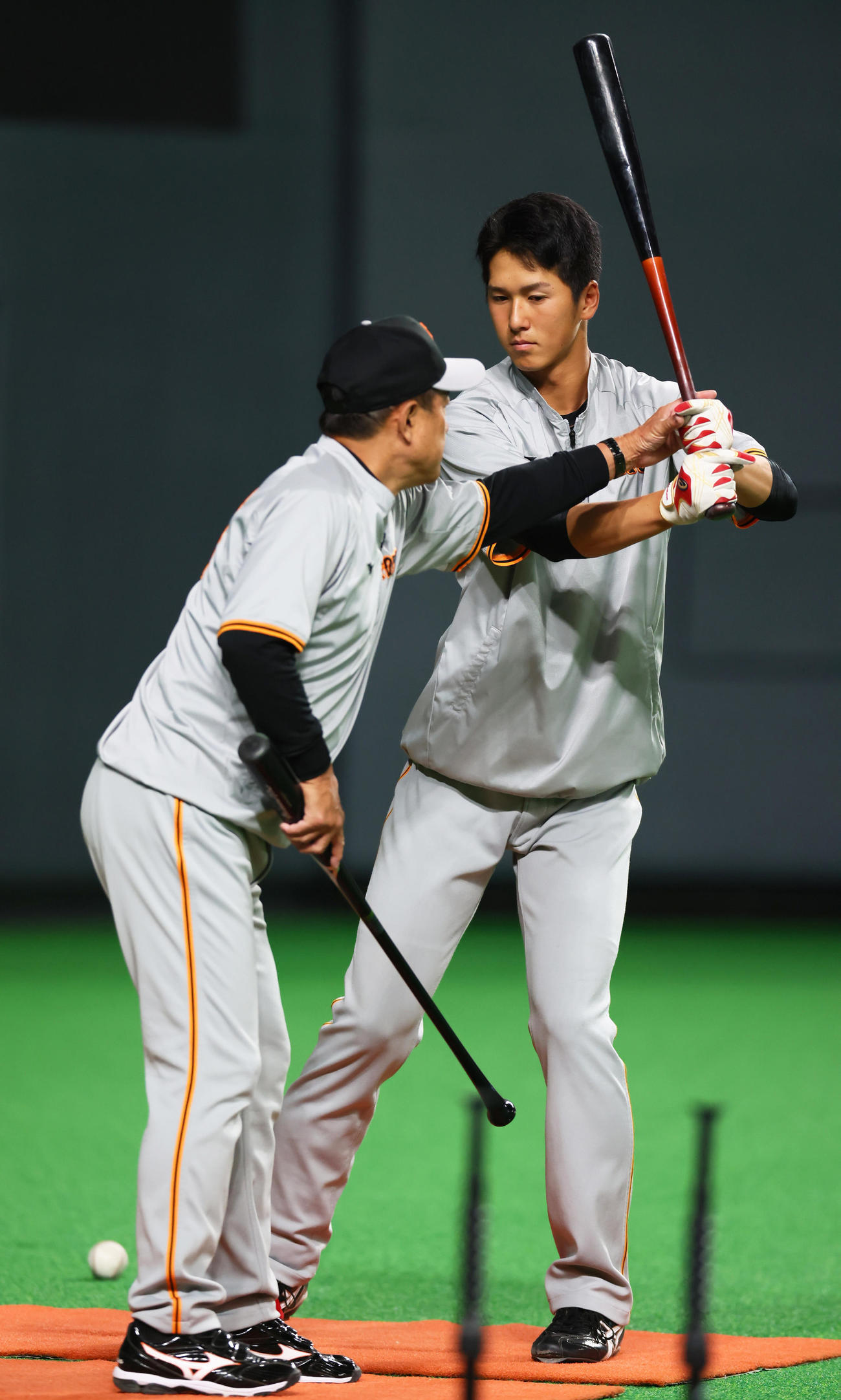 試合前、巨人原監督（左）から打撃指導を受ける秋広（撮影・足立雅史）