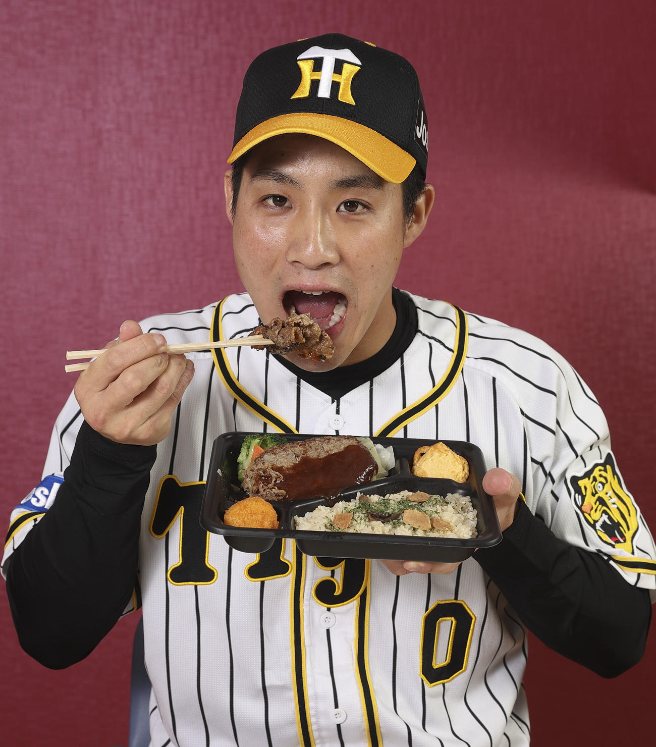阪神矢野監督と選手22人がプロデュースするコラボグルメ　プロデュースしたグルメを食す木浪聖也（阪神甲子園球場提供）