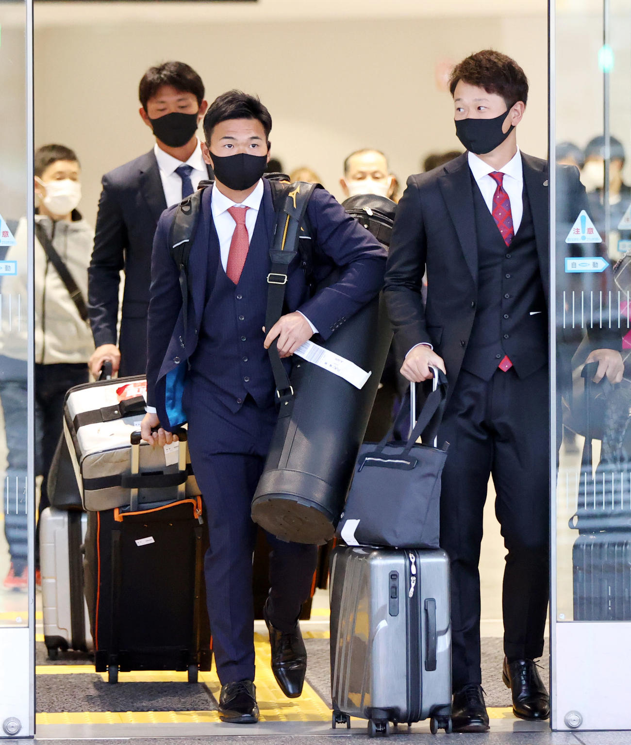 福岡空港に到着する、左から山下（左）と中川。左後方は平内（撮影・狩俣裕三）