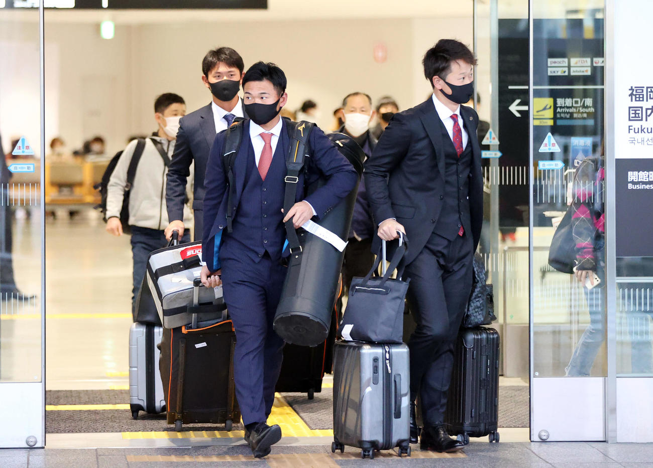 福岡空港に到着する、左から山下（左）と中川。左後方は平内（撮影・狩俣裕三）
