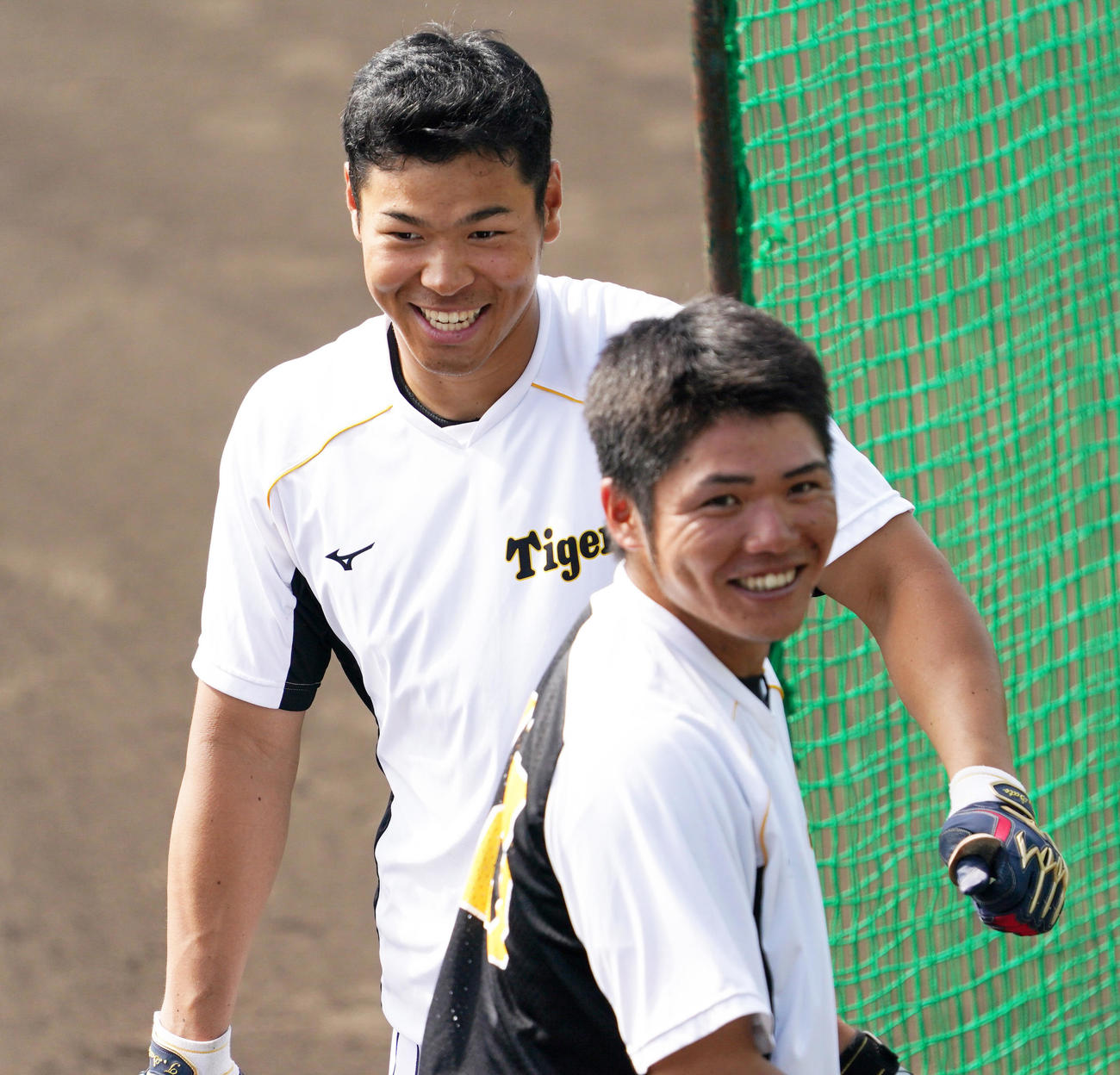 小野寺（手前）と笑顔をみせる佐藤輝（2021年3月1日撮影）