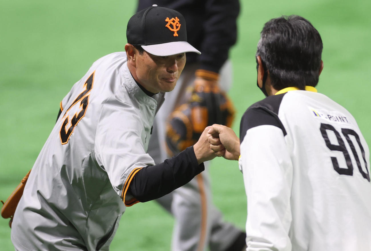 ソフトバンク対巨人　試合前、小久保ヘッドコーチ（手前）とタッチを交わす桑田投手チーフコーチ補佐（撮影・狩俣裕三）