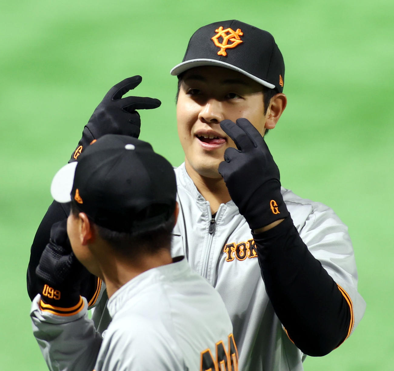 ソフトバンク対巨人　試合前、お茶目な表情を見せる岡本和。手前は山下（撮影・狩俣裕三）