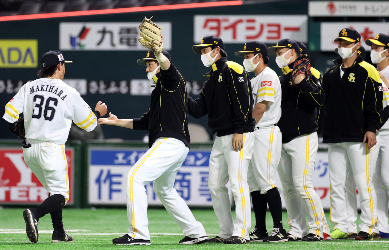 ソフトバンク対巨人　試合後、牧原（左）らチームメートを迎える松田（左から2人目）らソフトバンクの選手たち（撮影・狩俣裕三）