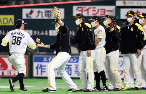 ソフトバンク対巨人　試合後、牧原（左）らチームメートを迎える松田（左から2人目）らソフトバンクの選手たち（撮影・狩俣裕三）