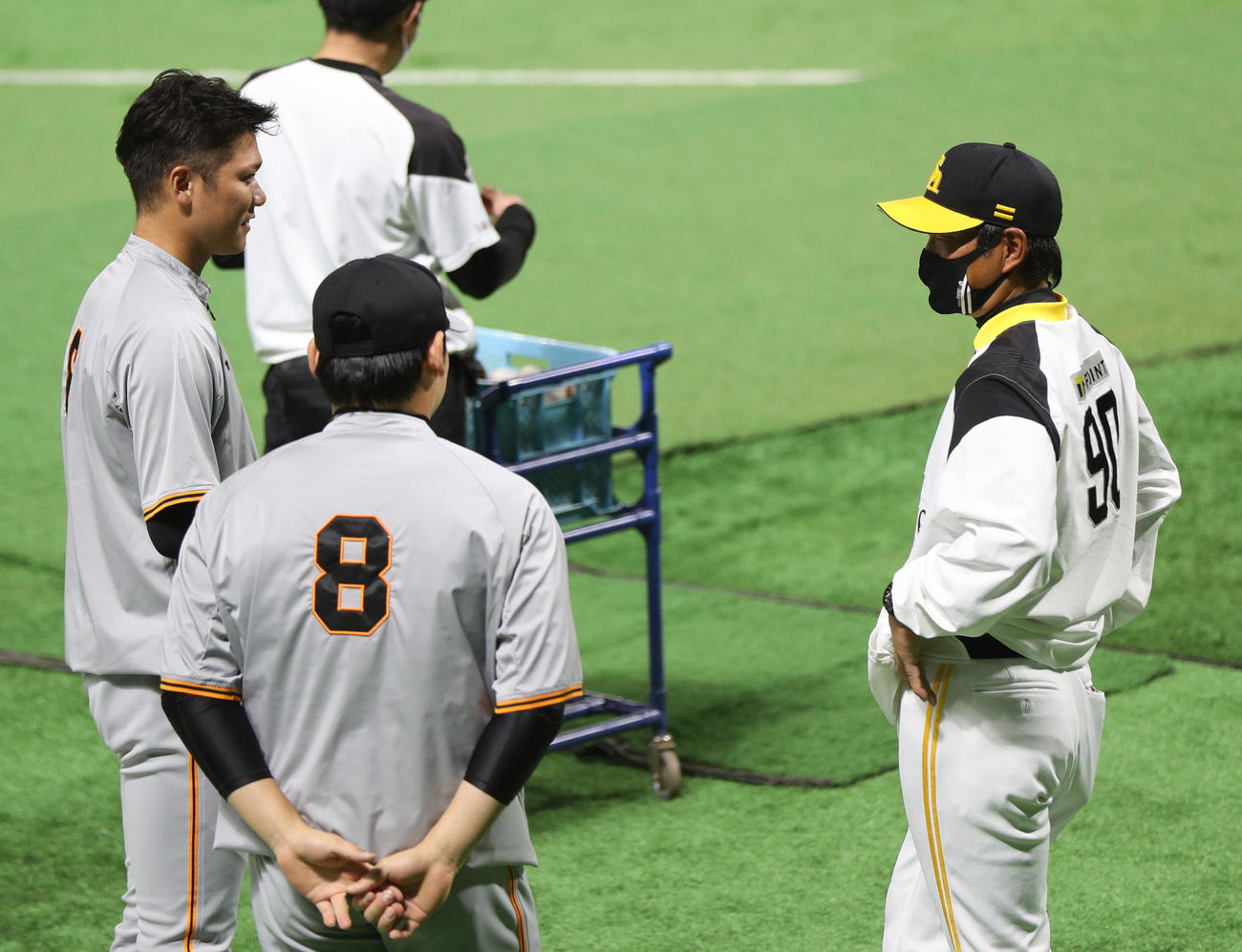 ソフトバンク対巨人　試合前、談笑する坂本（左）と小久保ヘッドコーチ。手前は丸（撮影・狩俣裕三）