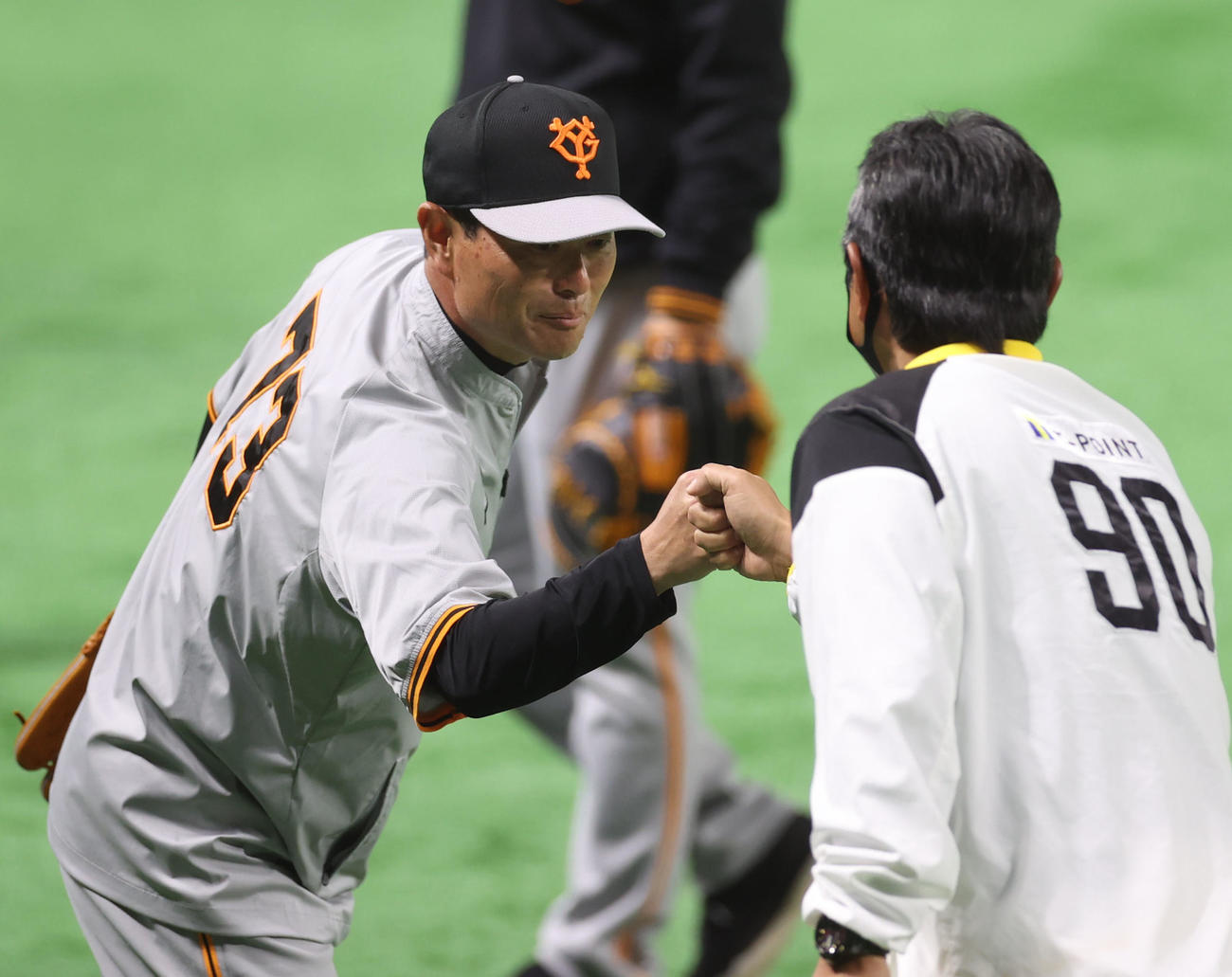 ソフトバンク対巨人　試合前、小久保ヘッドコーチ（手前）とタッチを交わす桑田投手チーフコーチ補佐（撮影・狩俣裕三）