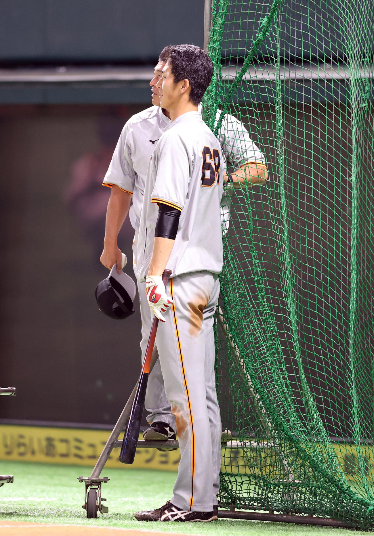ソフトバンク対巨人　打撃ネットの柱に乗っかった石井野手総合コーチ（後方）と背比べする秋広（撮影・狩俣裕三）