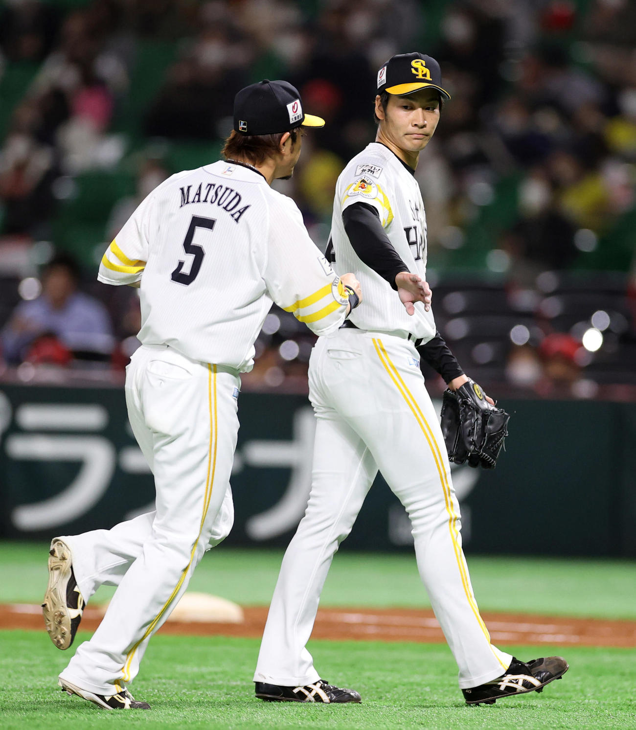 ソフトバンク対巨人　2回表を終え、松田（左）とタッチを交わすソフトバンク先発の武田（撮影・狩俣裕三）