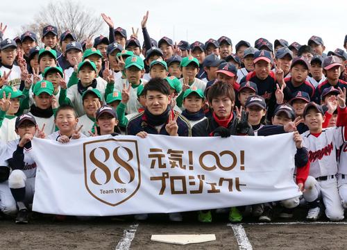 12年12月　被災地福島を訪れ（中央左）、広島中村（同右）や選手たちと笑顔でVサイン