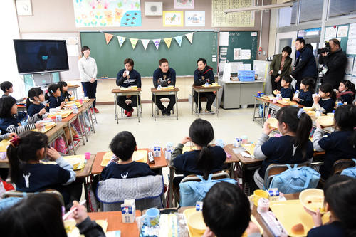 18年1月、仙台市立六郷小の生徒たちと給食を楽しむ（中央）。左は楽天辛島、右は永井ジュニアコーチ
