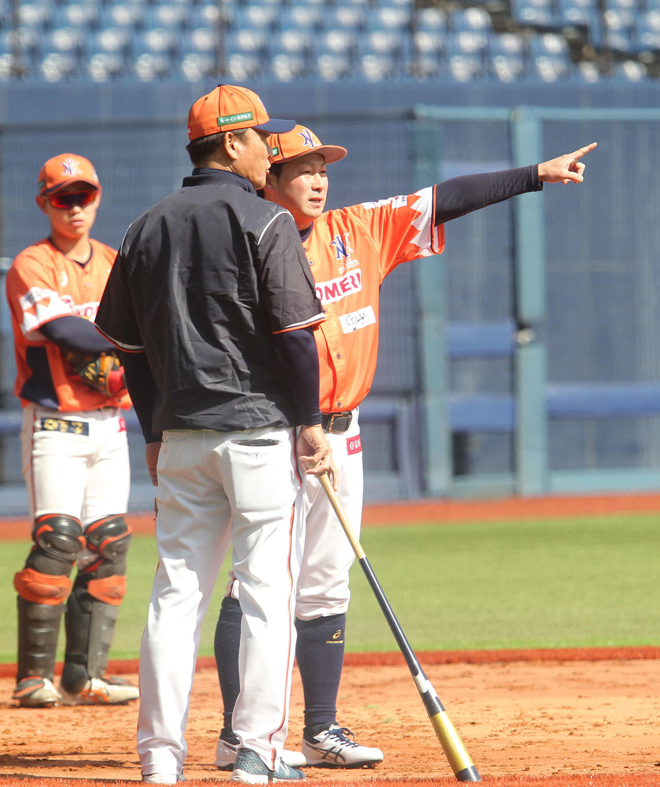 橋上監督（背中）と練習の打ち合わせをする稲葉内野手兼野手コーチ（右）