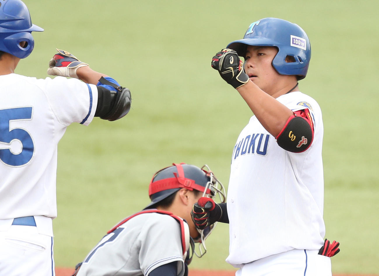昨年10月14日、宮教大戦の5回に左越え本塁打を放ち、仲間とエアタッチする東北大・桜井優（右）