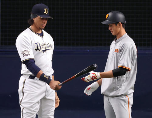 オリックス対巨人　練習でオリックススティーブン・モヤ（左）にバットを貸す秋広優人（撮影・清水貴仁）