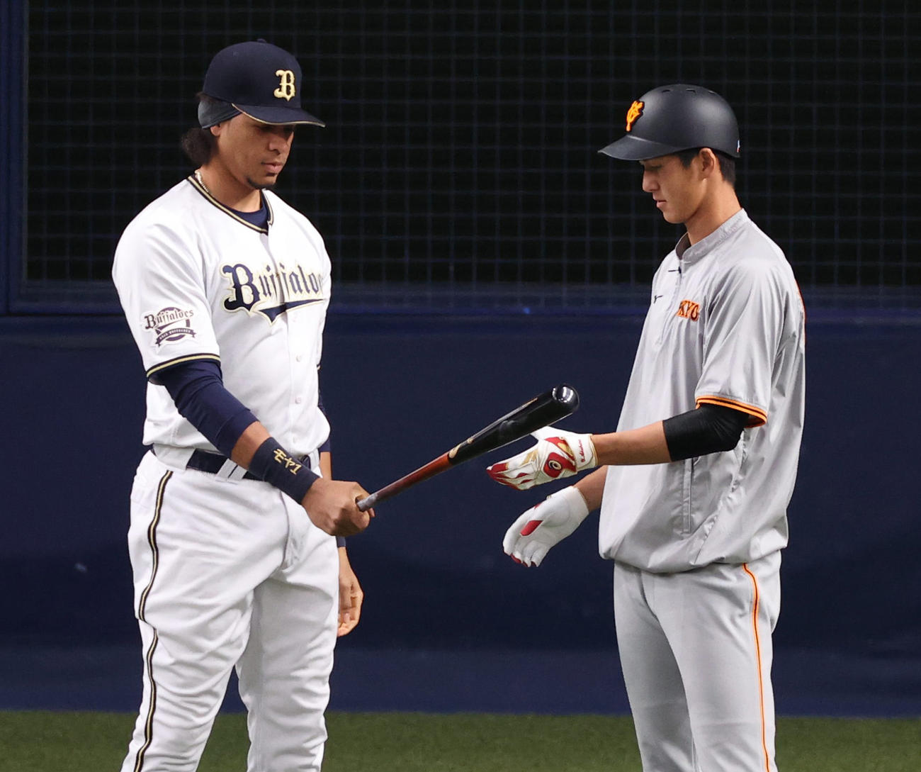 オリックス対巨人　練習でオリックススティーブン・モヤ（左）にバットを貸す秋広優人（撮影・清水貴仁）