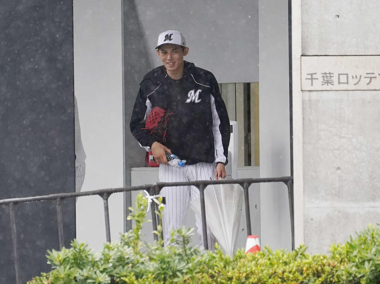 練習を終え、笑顔で室内練習場を出るロッテ佐々木朗（撮影・鈴木みどり）