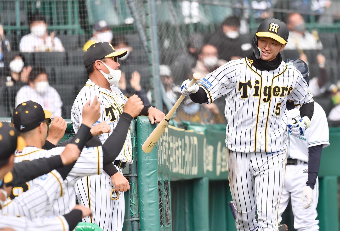 阪神対西武　5回裏阪神1死、右越えに同点ソロ本塁打を放った近本はナインの出迎えに笑顔を見せる（撮影・上田博志）