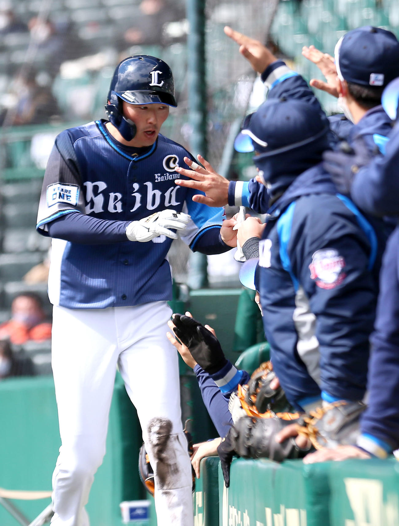 阪神対西武　4回表西武無死二塁、源田（左）は外崎の三ゴロから守備のスキをつき先制生還しベンチの出迎えを受ける（撮影・上山淳一）