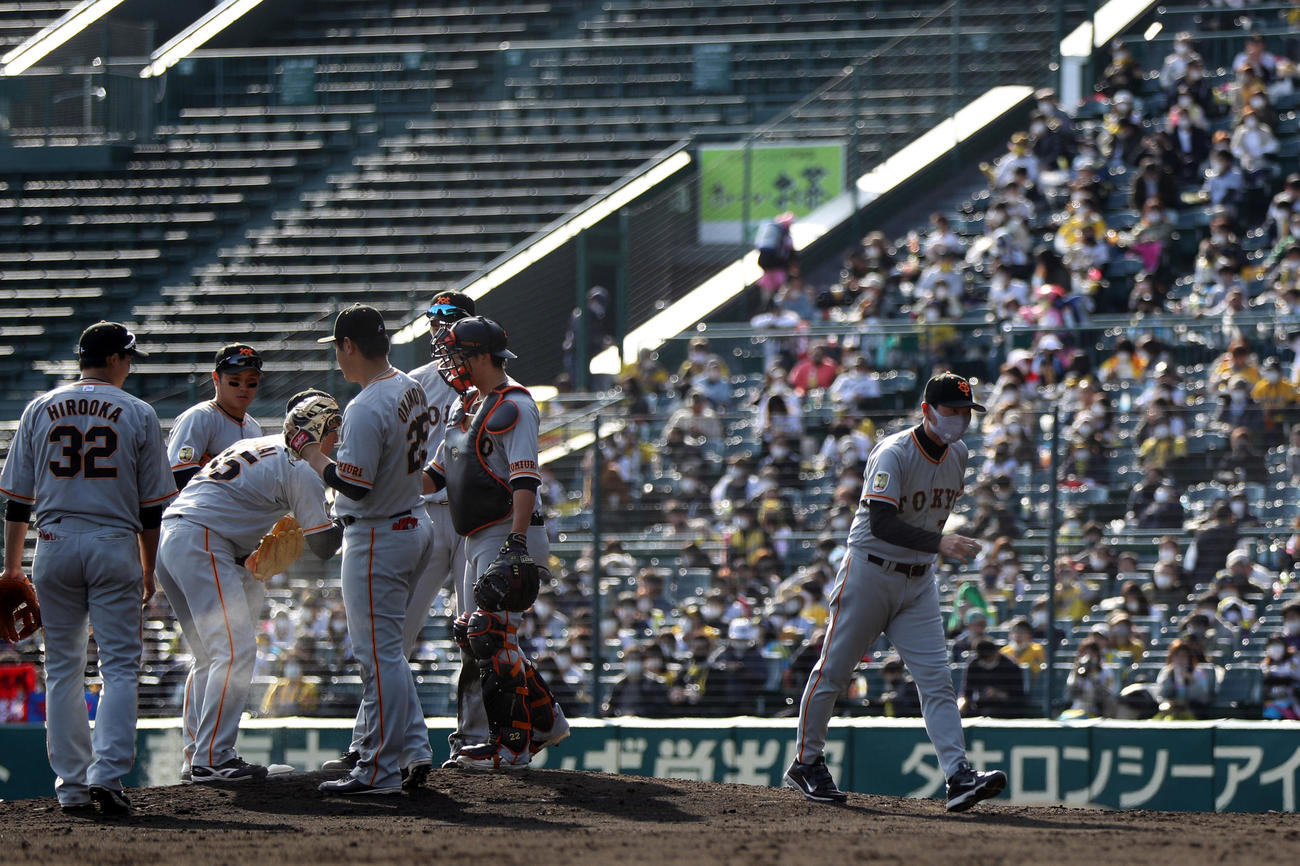 阪神対巨人　8回裏阪神1死一塁、マウンドの桜井、内野陣と話をし、ベンチに引き揚げる桑田投手チーフコーチ補佐（撮影・狩俣裕三）