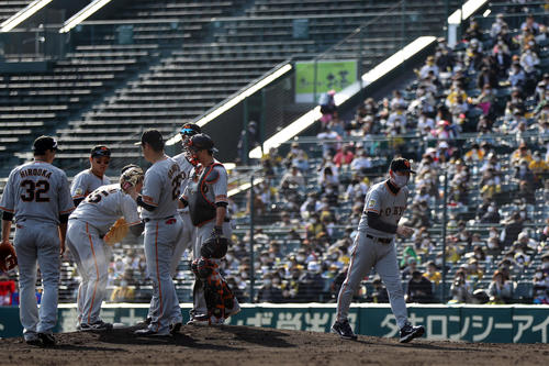 阪神対巨人　8回裏阪神1死一塁、マウンドの桜井、内野陣と話をし、ベンチに引き揚げる桑田投手チーフコーチ補佐（撮影・狩俣裕三）