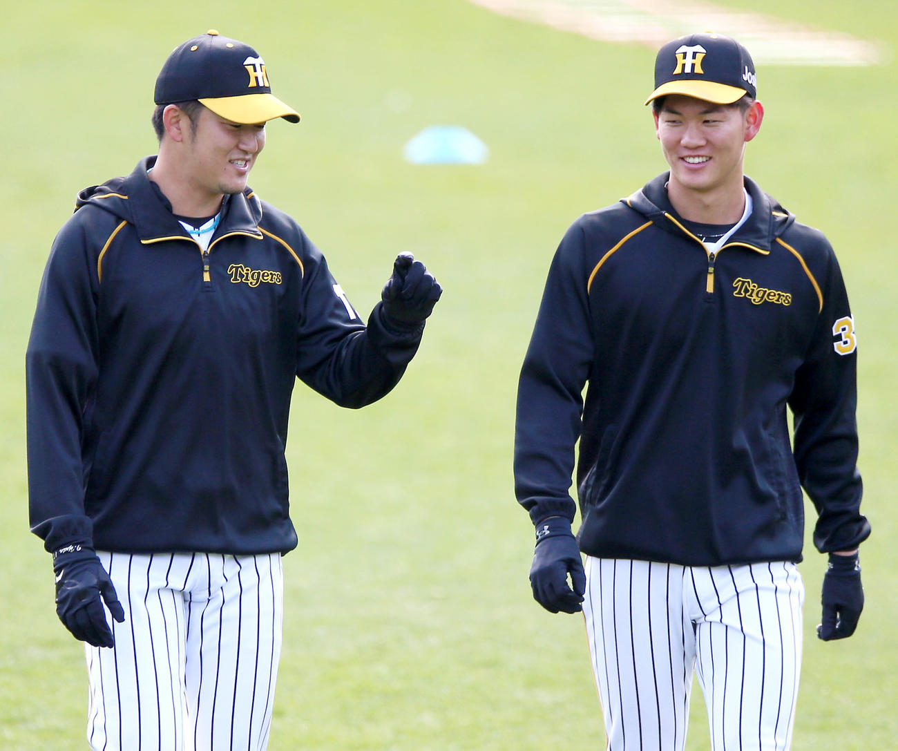 阪神対巨人　試合前の練習で岩貞（左）と話す及川（撮影・上山淳一）