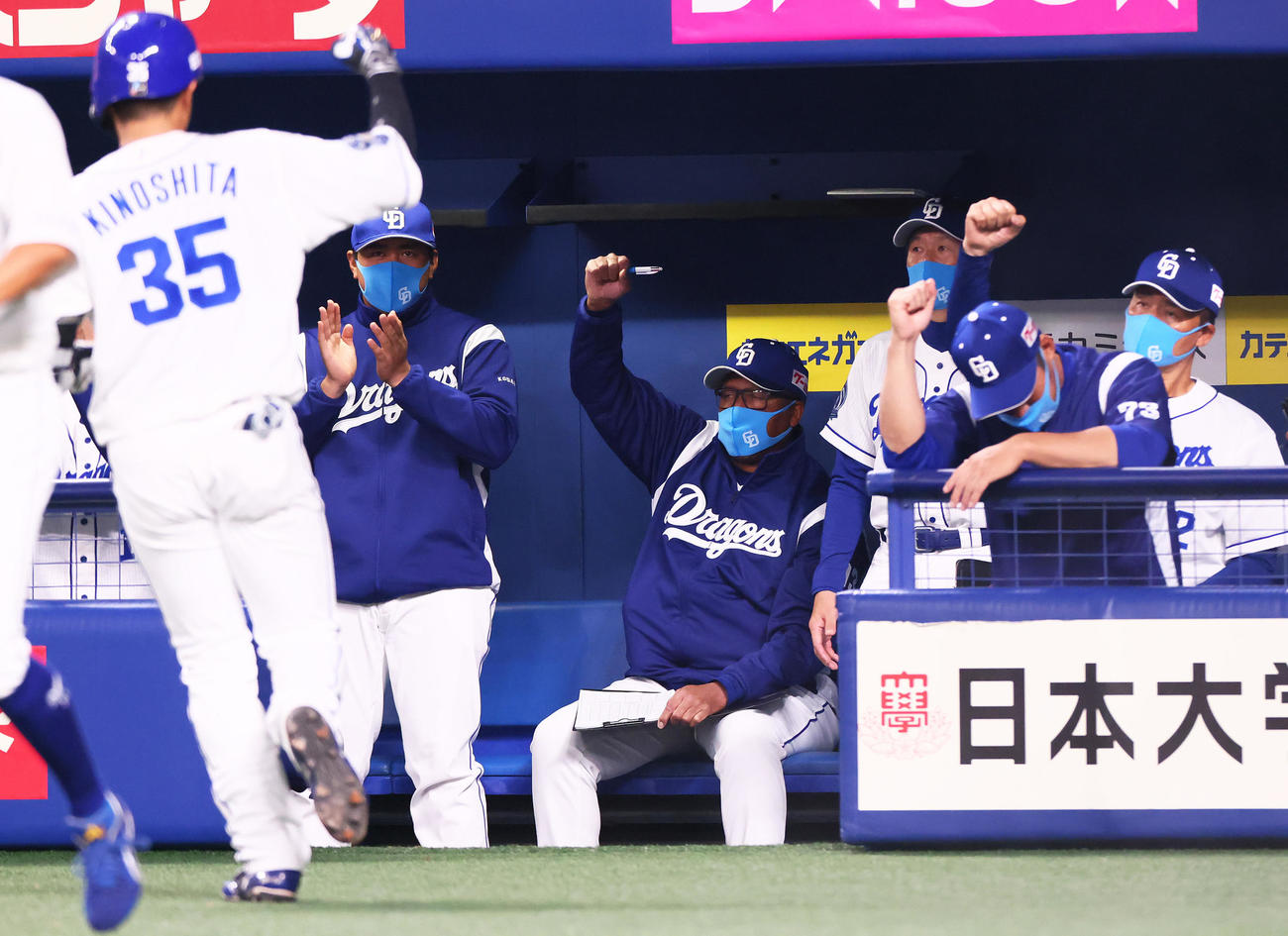 中日対巨人　2回裏中日2死一塁、左越え2点本塁打を放った木下（左端35）をガッツポーズで迎える与田監督（右端）ら（撮影・足立雅史）