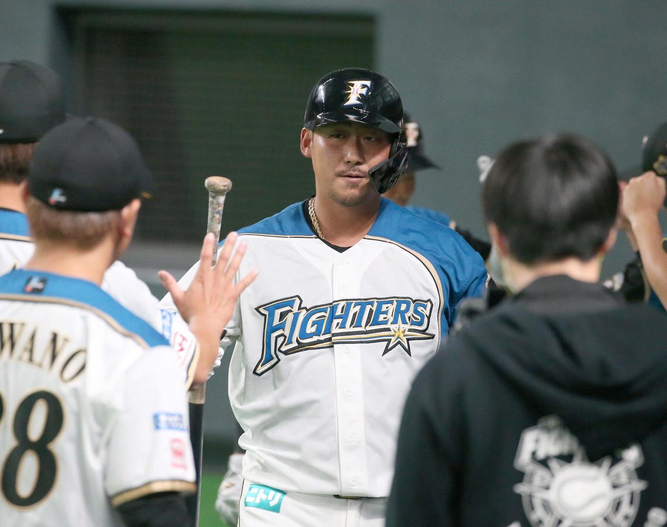 日本ハム対ロッテ　1回裏日本ハム2死一塁、左越え2点本塁打を放ち出迎えられる中田（撮影・黒川智章）