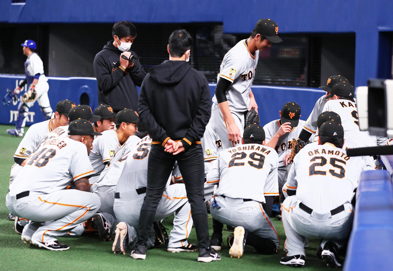 試合前の声出しに指名され円陣の中心に向かう巨人秋広（撮影・足立雅史）