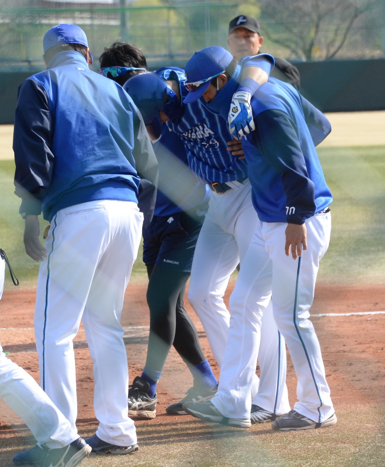 代打で左前打を放ったDeNA伊藤光（中央）は左足首付近を痛めたとみられ、肩を借りてベンチへ退き途中交代となった（撮影・鈴木正章）