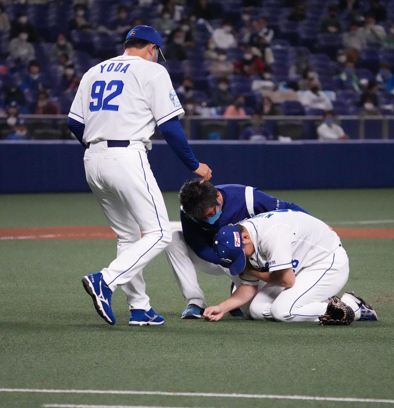 オープン戦・中日対日本ハム　8回表日本ハム2死、投球後、腕を押さえうずくまる木下雄介のもとに駆け寄る与田剛監督（撮影・森本幸一）