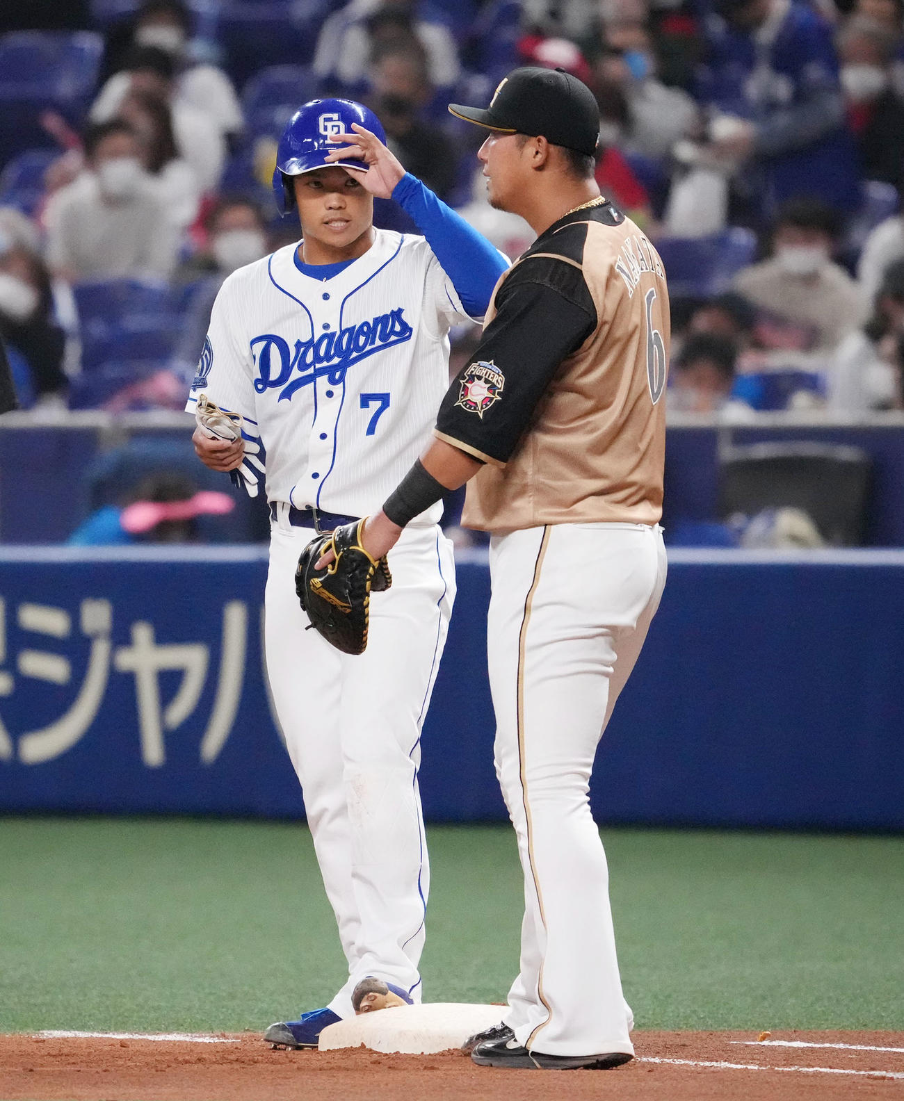中日対日本ハム　4回裏中日無死、遊撃内野安打を放った根尾昂（左）と一塁手の中田翔（右）（撮影・森本幸一）
