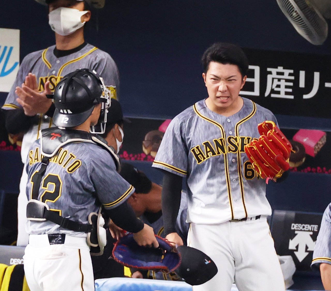 7回裏を無失点に抑え捕手坂本誠志郎（左）とタッチを交わす石井大智（撮影・清水貴仁）