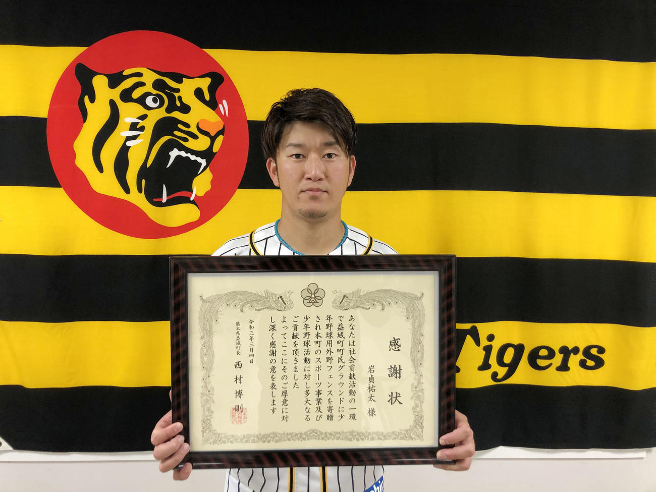 これまでの社会貢献活動について、熊本県益城町の西村町長から贈られた感謝状を手にする岩貞（球団提供）